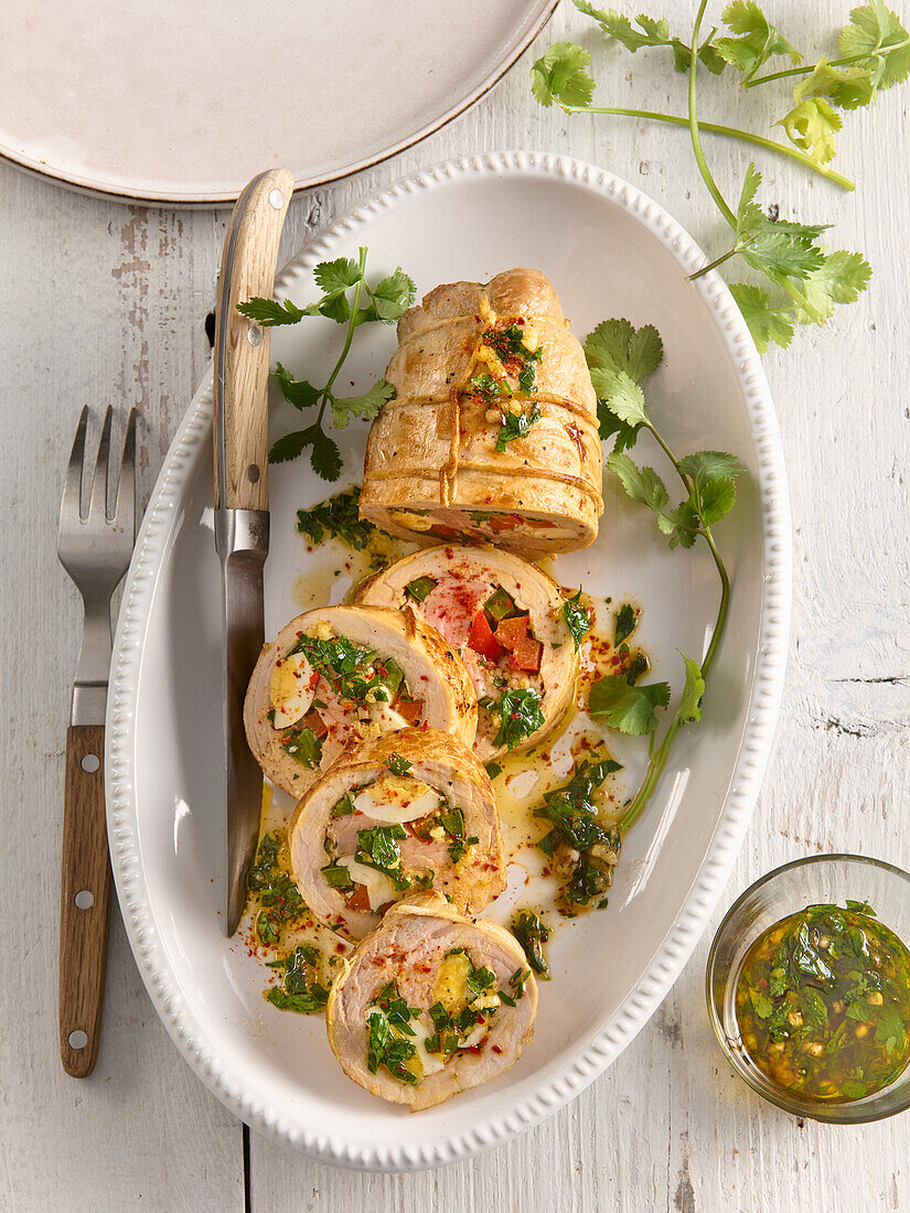 Stuffed giant pork roulade with peppers and herbs