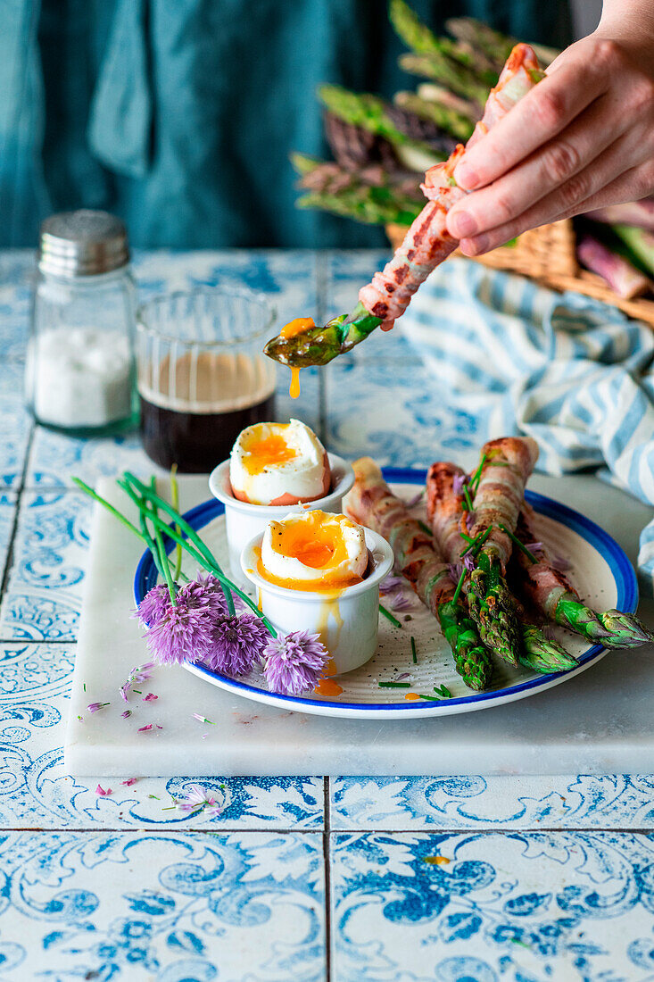 Green asparagus wrapped in ham with a breakfast egg