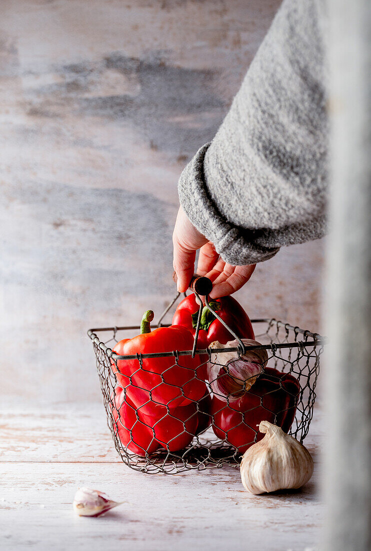 Rote Paprika und Knoblauch in Drahtkorb