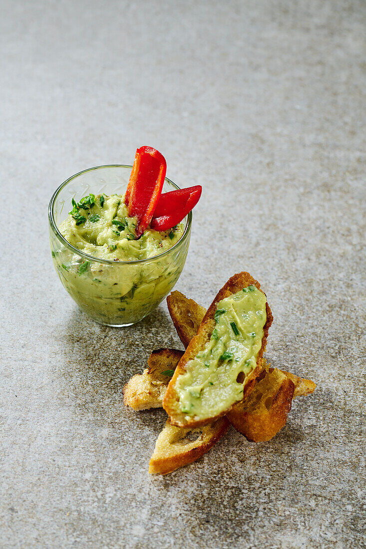 Guacamole mit Paprikastreifen und geröstetem Brot