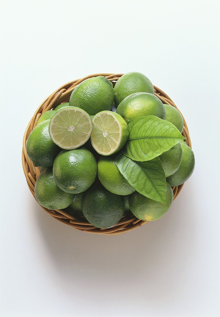 Limes in basket, one halved on top