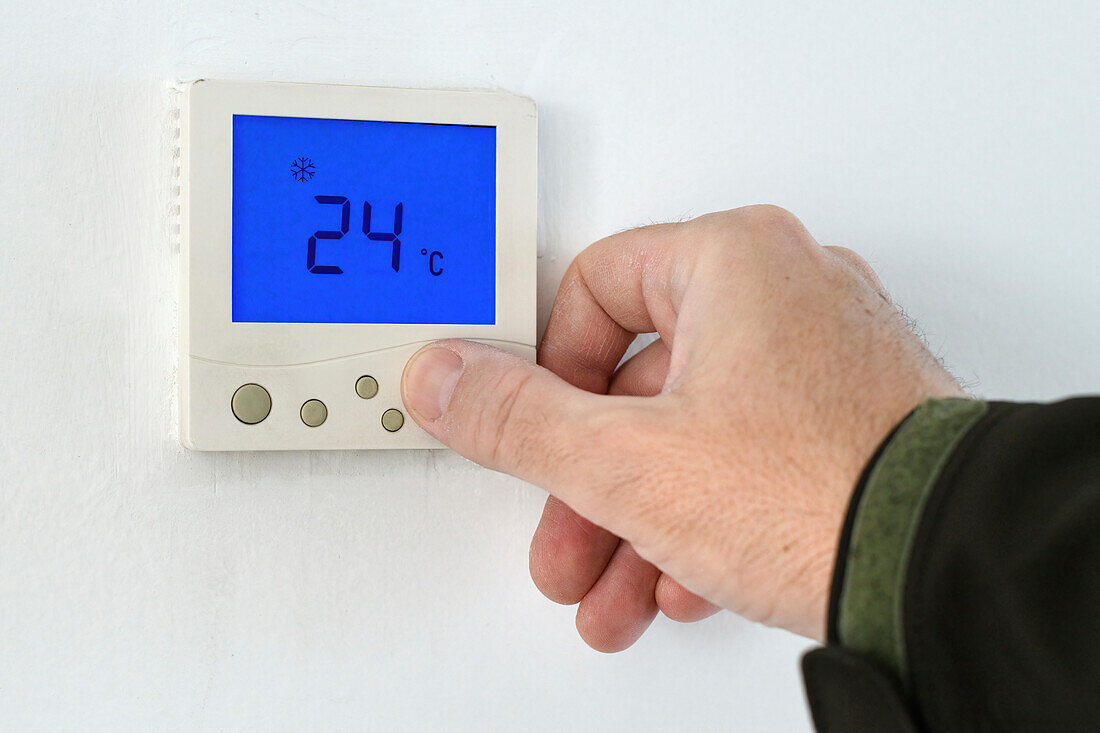 Man using home heating and cooling control unit