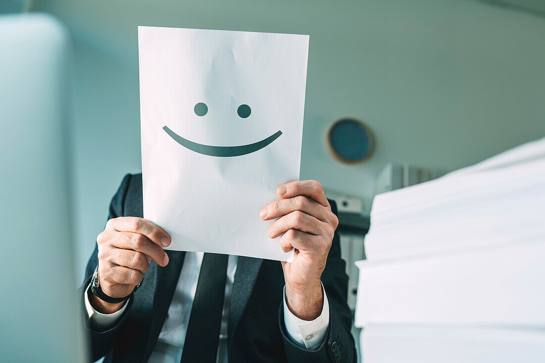 Professional man holding paper with smiling emoticon