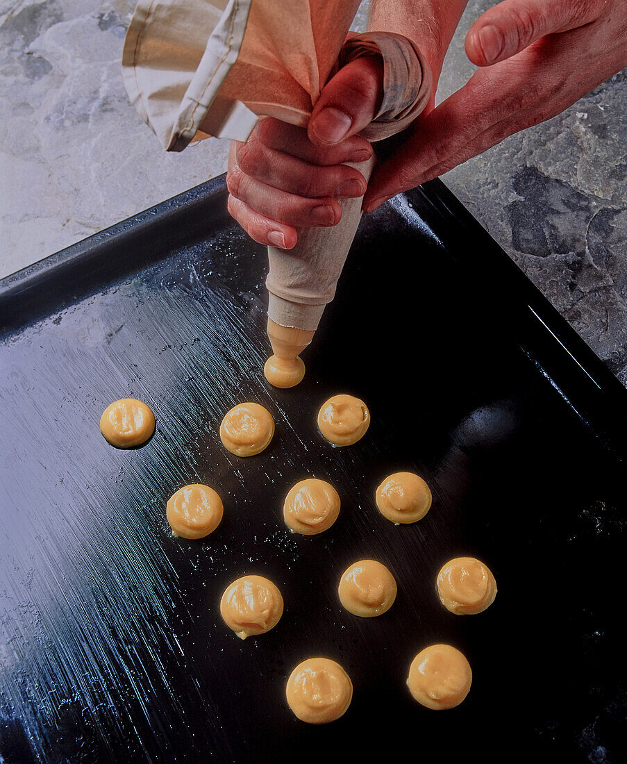 Profiteroles-Teig auf Backblech dressieren