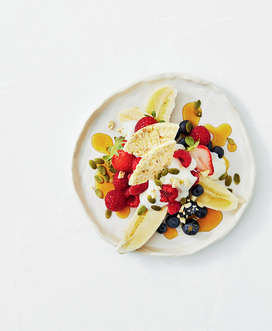 Fruchtsalat mit Banane, Beeren, Joghurt und Nüssen