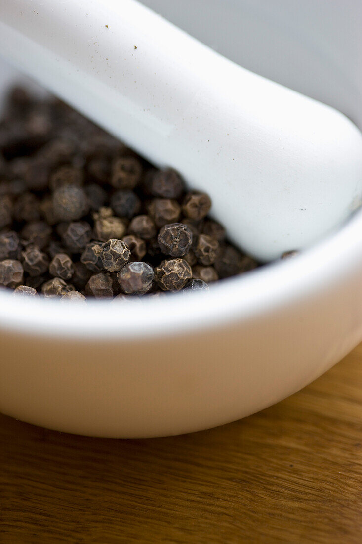 Mortar and Pestle Filled with Black Peppercorns