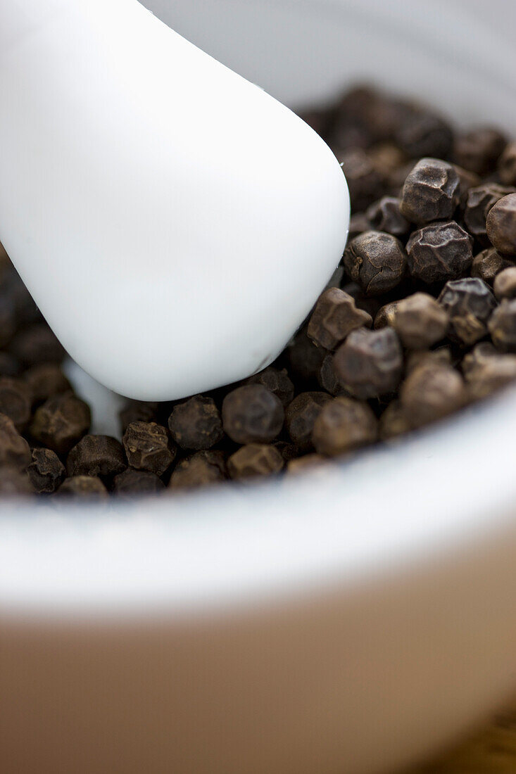 Mortar and Pestle Filled with Black Peppercorns