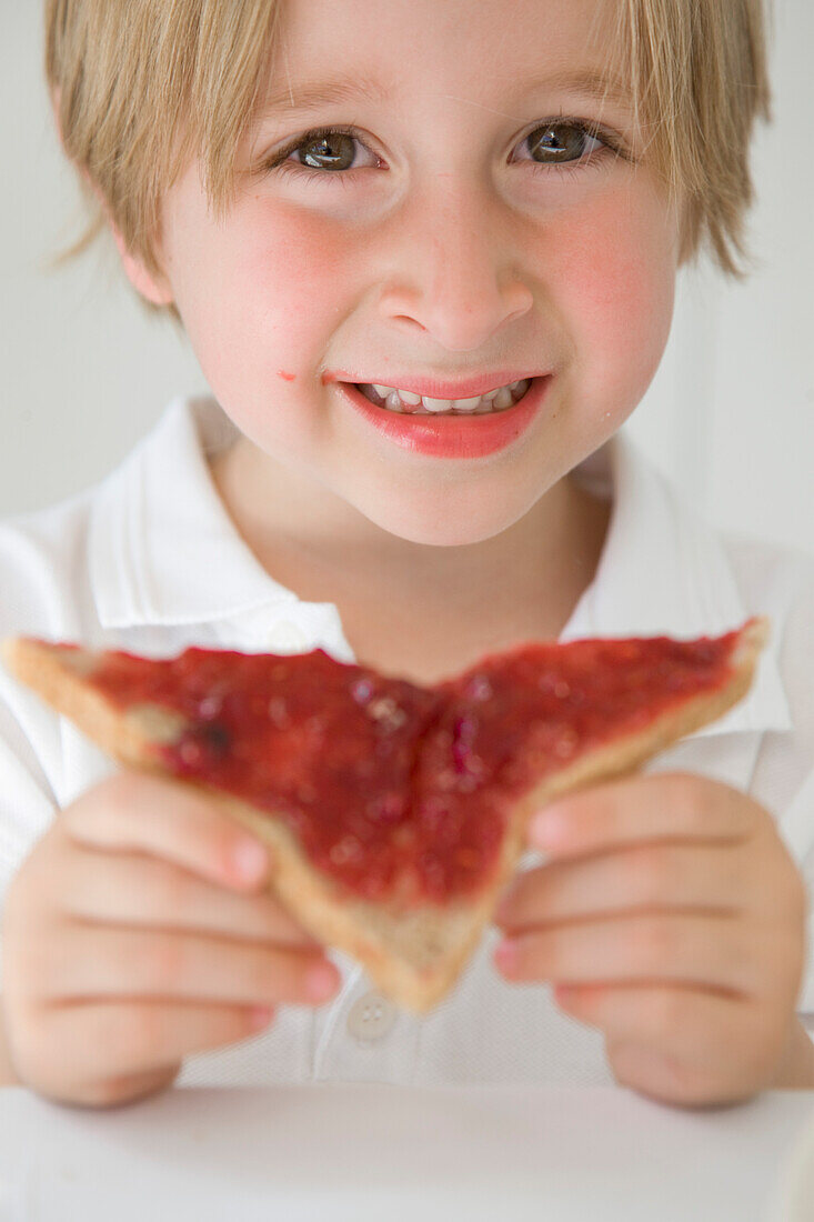 Junge isst Marmelade auf Toast