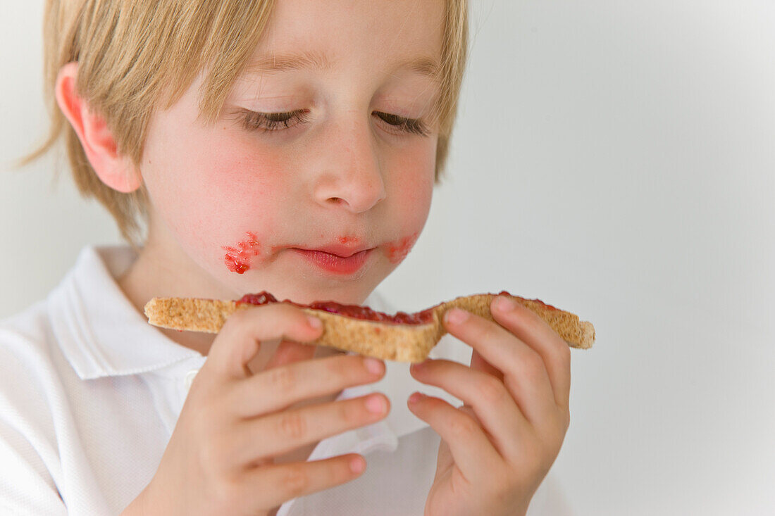 Junge isst Marmelade auf Toast