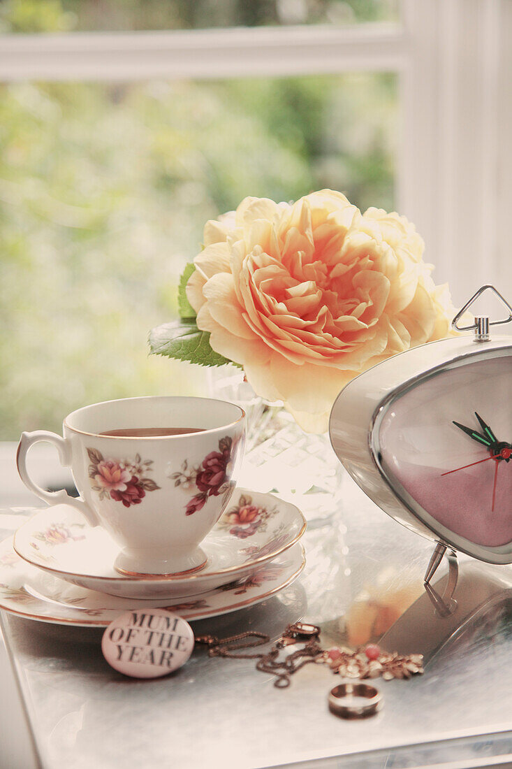 Teacup, Clock, Jewelry and Flowers on Woman's Dressing Table