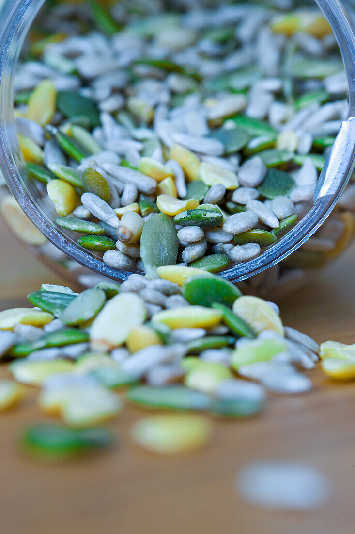 Close up of mixed seeds spilling out of a container