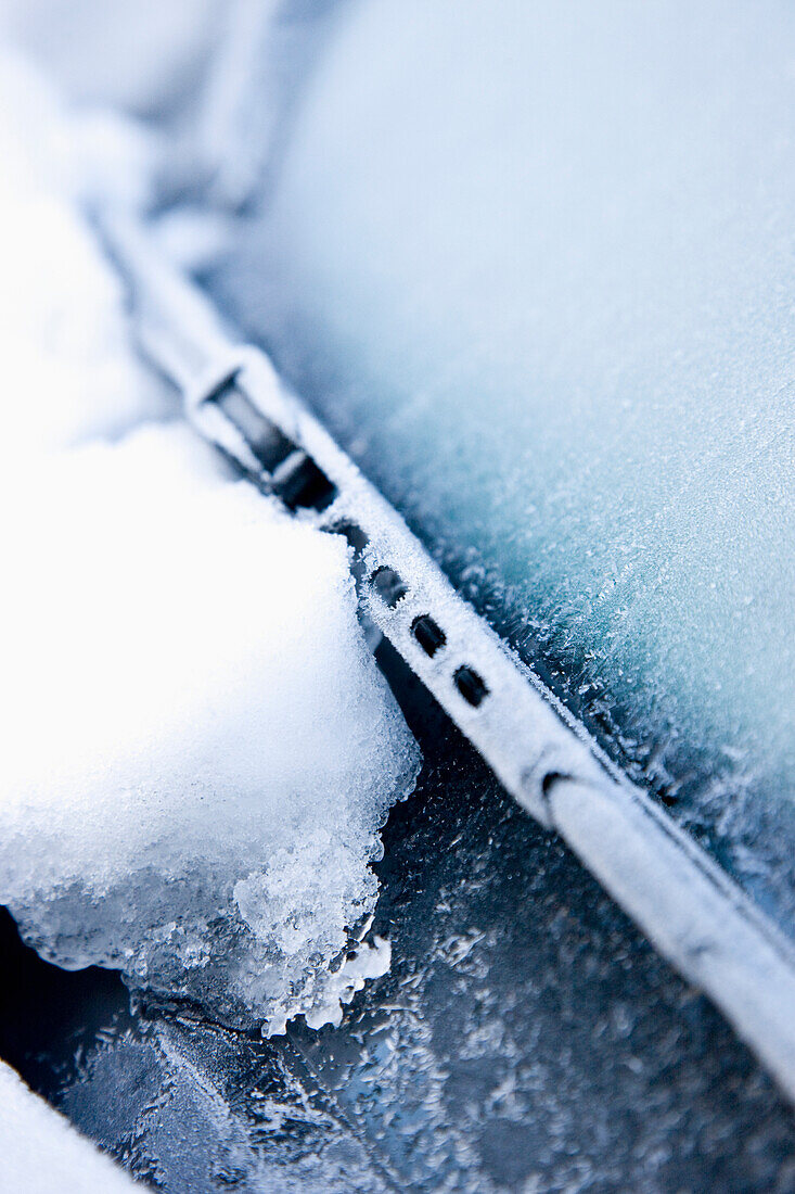 Nahaufnahme von Schnee und Eis auf der Windschutzscheibe eines Autos