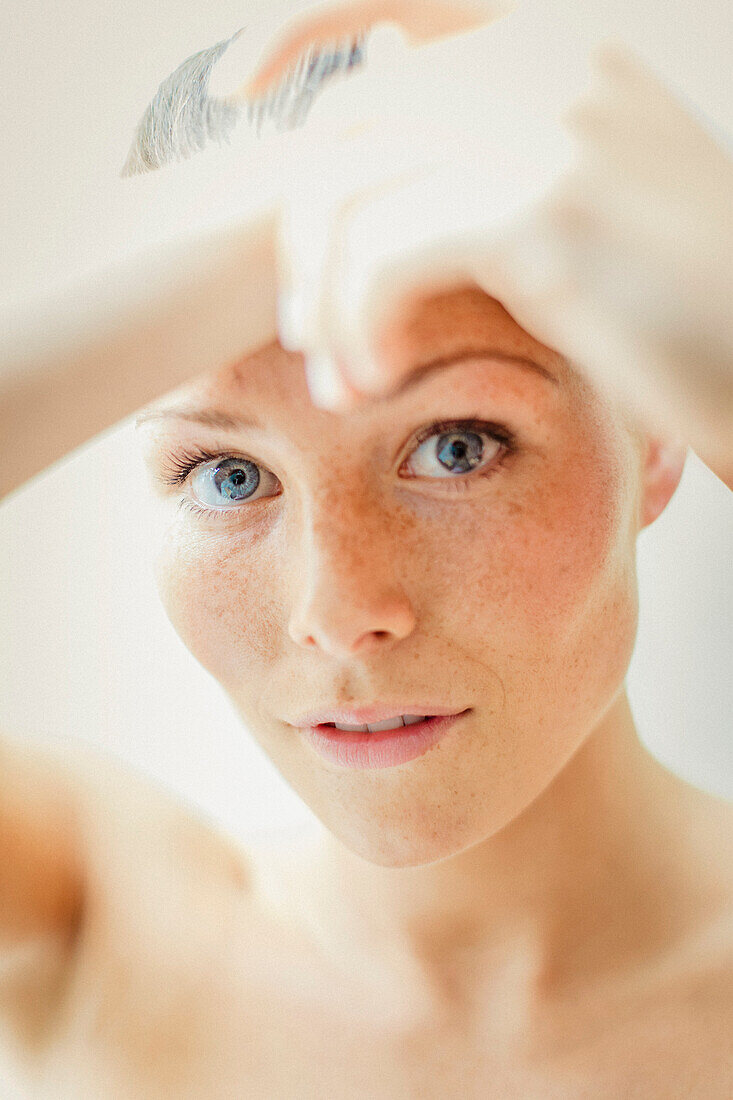 Schönheitsporträt einer Frau mit Händen auf dem Gesicht