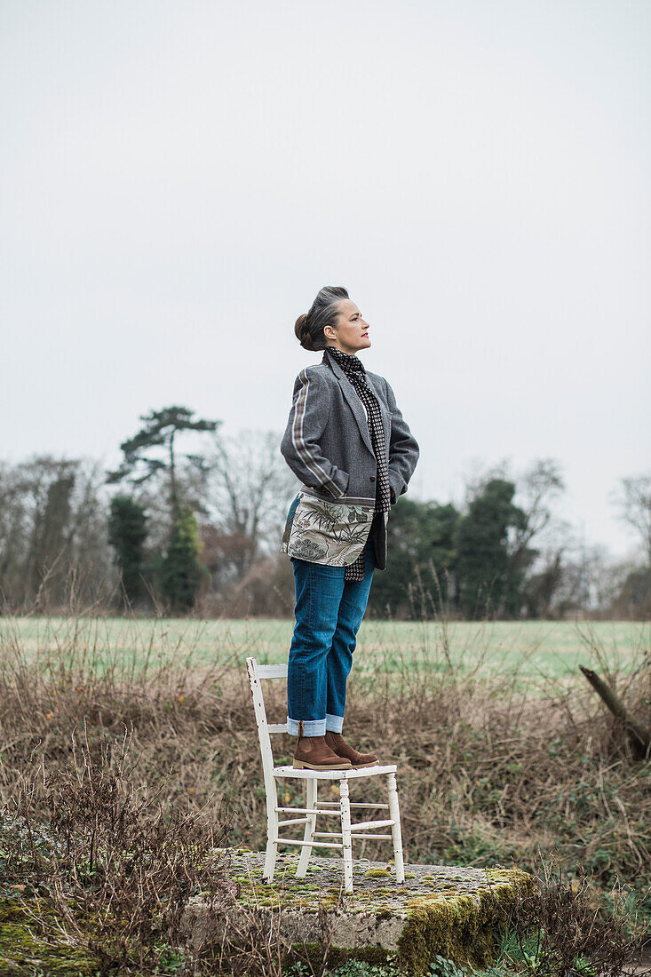 Woman Standing on Chair in a Field