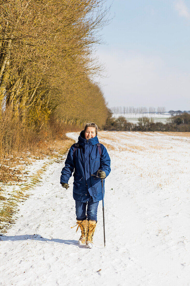 Frau beim Wandern auf schneebedecktem Feld