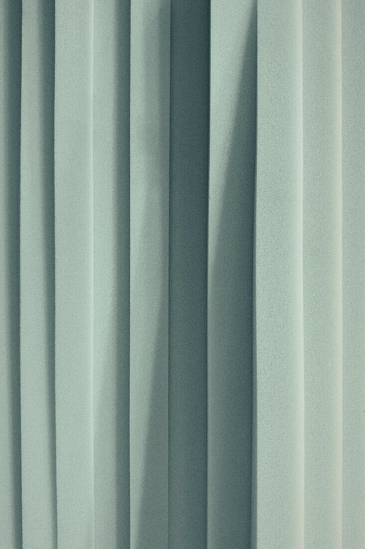 Full frame close up shadow over pale blue overlapping strips