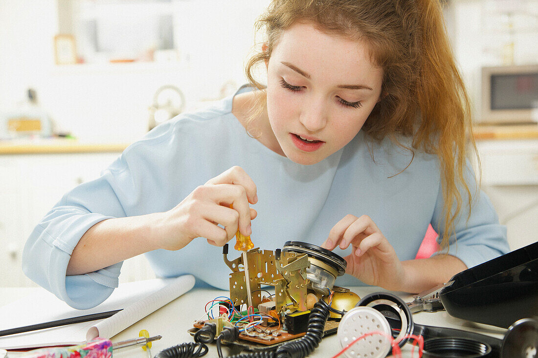 Teenager-Mädchen baut ein Telefon für ein technisches Schulprojekt