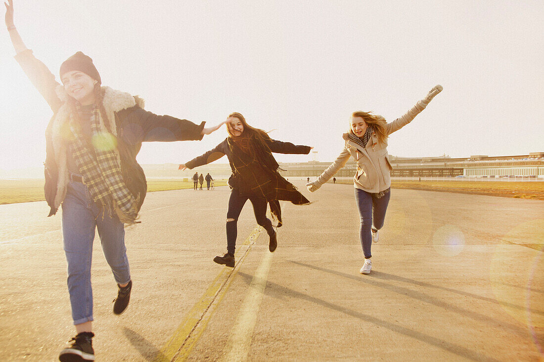 Teenage Girls Running with Arms Outstretched