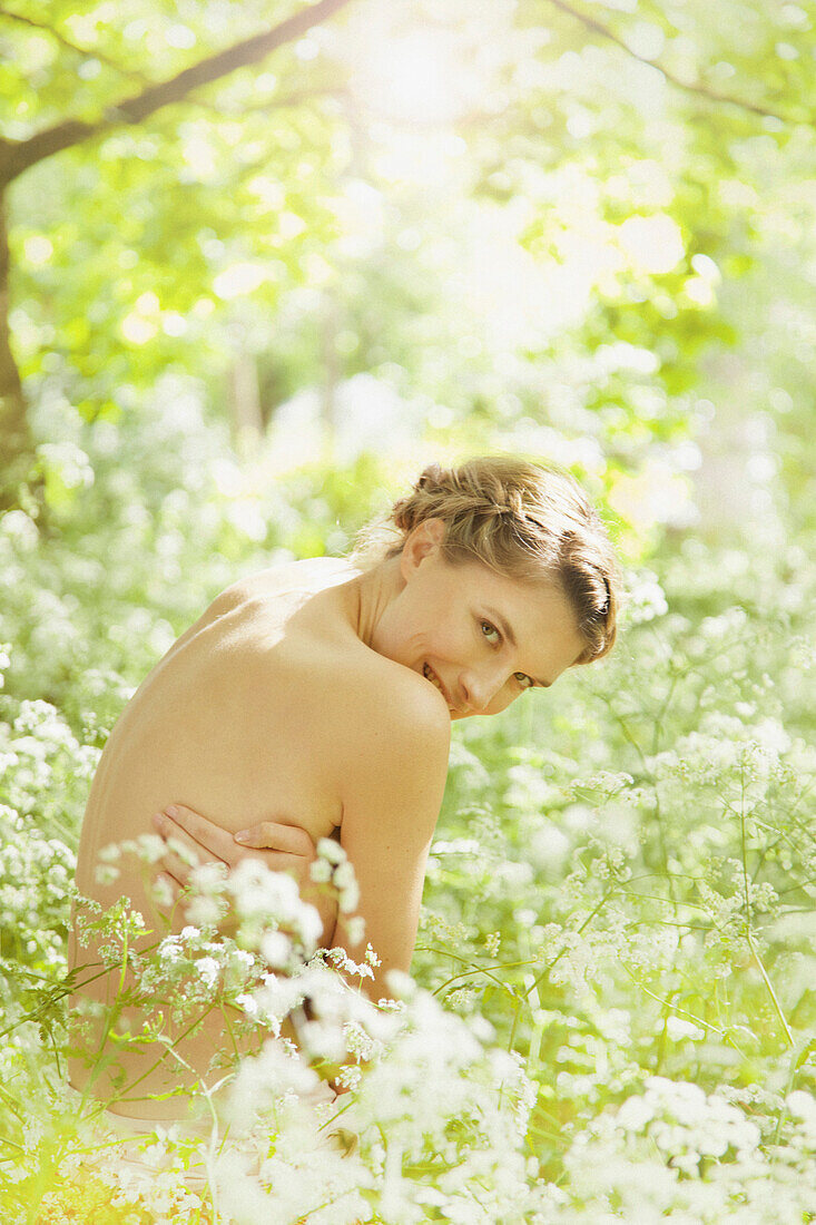 Nude Woman Hugging herself in a Meadow Smiling