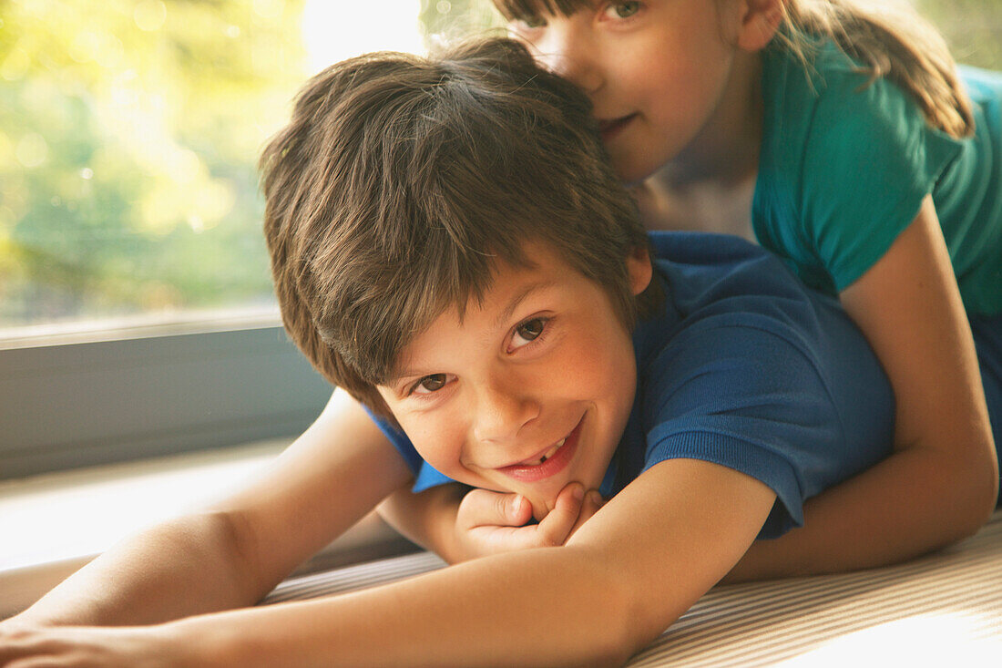 Young Girl Lying on Brother's Back