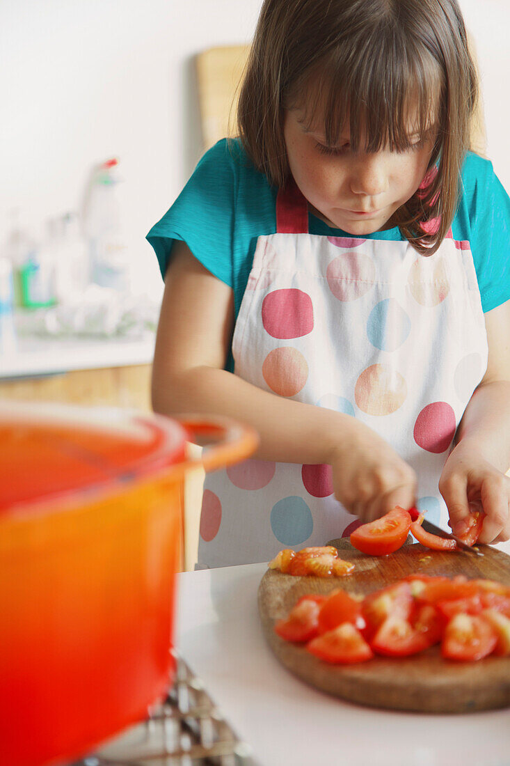 Junges Mädchen schneidet Tomaten