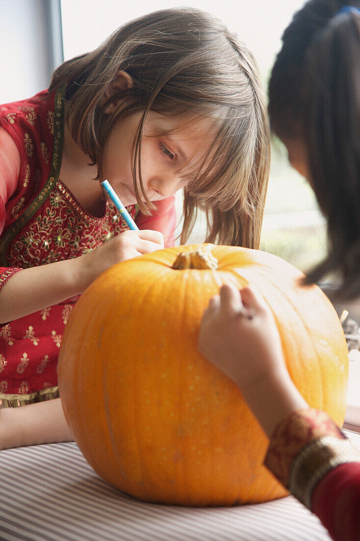 Young Girls Making a Pumpkin Lantern