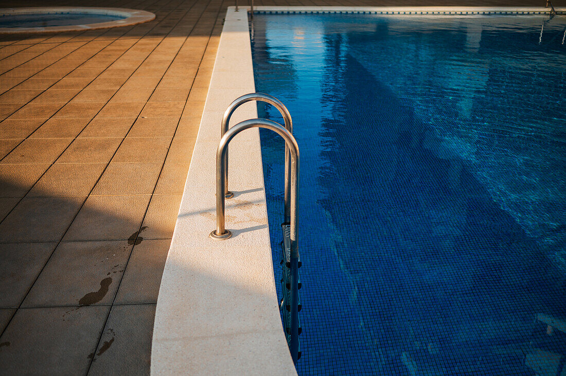 Pool in einer privaten Wohnanlage in Peñiscola bei Sonnenuntergang, Castellon, Valencianische Gemeinschaft, Spanien