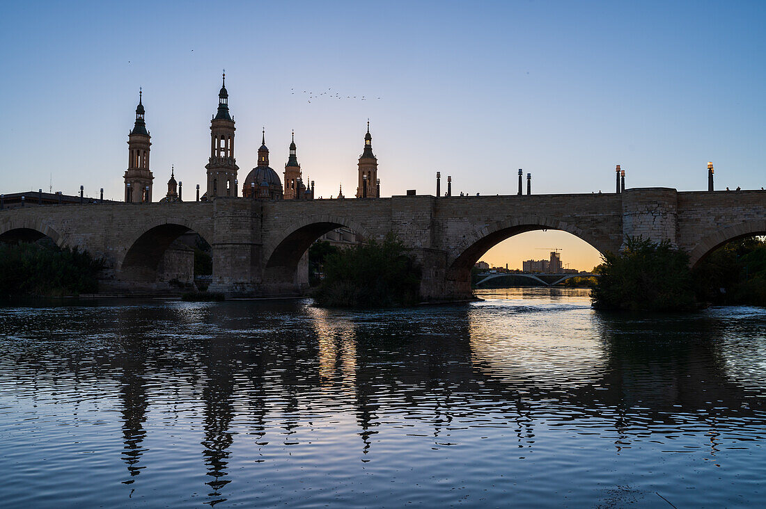 Cathedral-Basilica of Our Lady of the Pillar and the Ebro River bank at sunset, Zaragoza, Spain