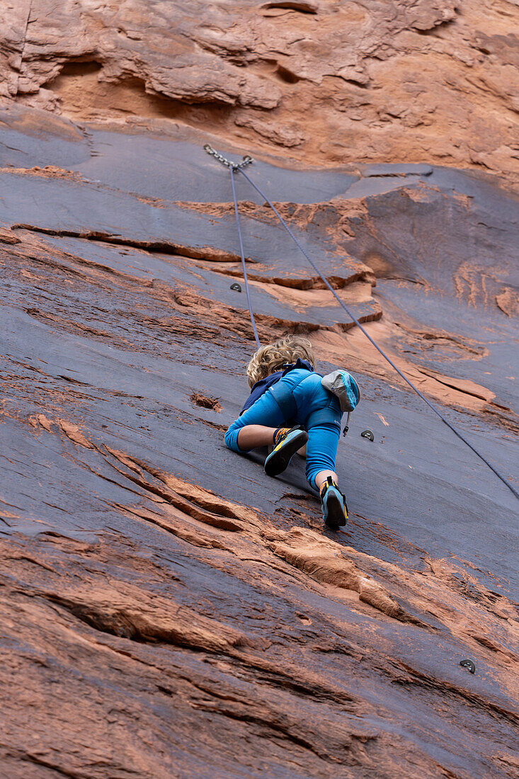 A young boy, age 6, learning to rock climb in Hunter Canyon near Moab, Utah.