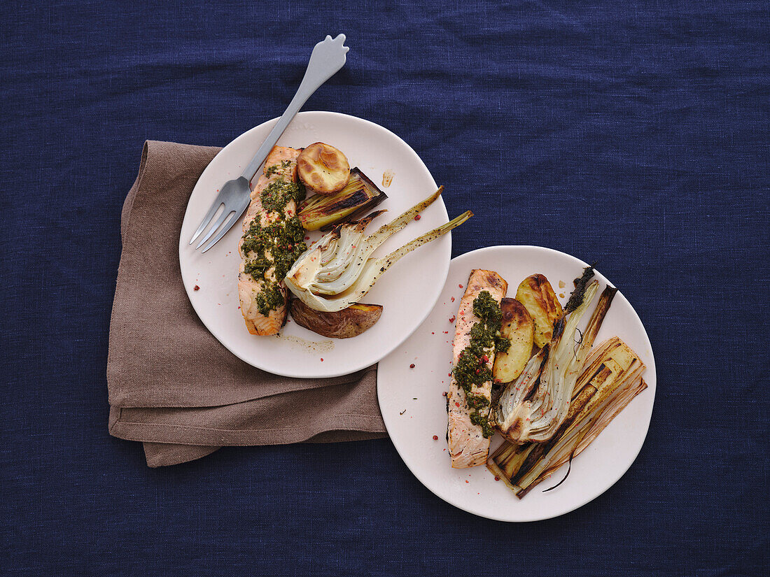 Still life table top view healthy meal of grilled salmon with pesto, leeks, and baked potato