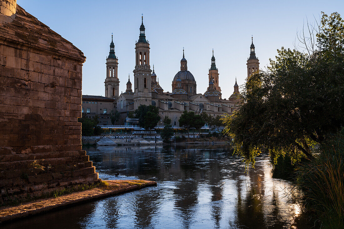 Cathedral-Basilica of Our Lady of the Pillar and the Ebro River bank at sunset, Zaragoza, Spain