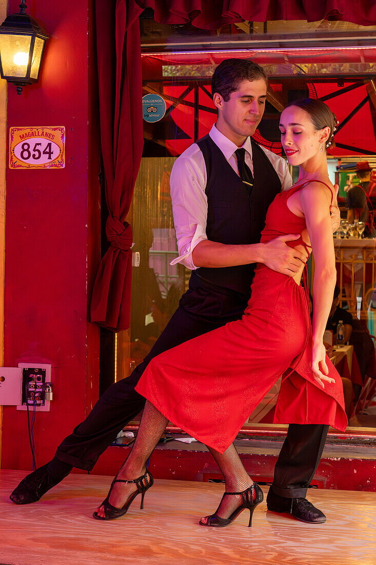 Ein attraktives junges Paar tanzt Tango auf El Caminito im Stadtteil La Boca von Buenos Aires, Argentinien.