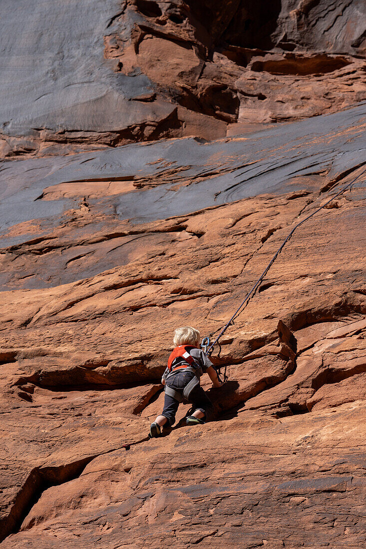 A young boy, age 3, learning to rock climb in Hunter Canyon near Moab, Utah.