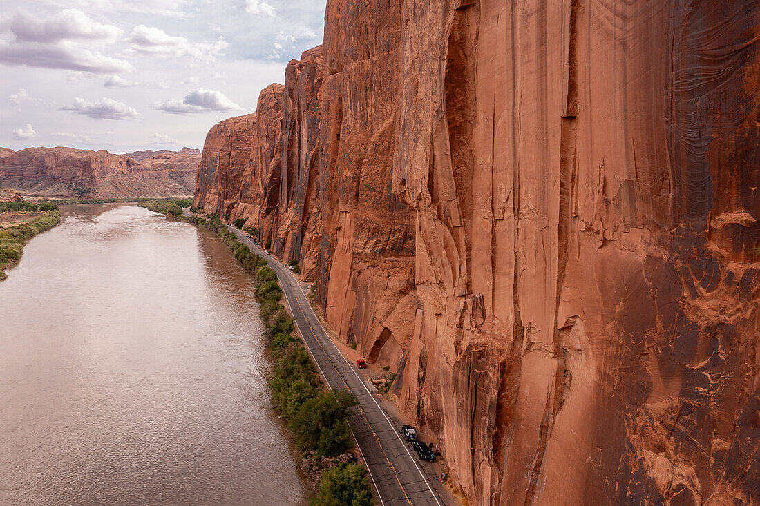 Aerial view of the Wingate Cliffs along Hwy 279 along the Colorado River near Moab, Utah. Note the parked vehicles of the rock climbers along Wall Street.