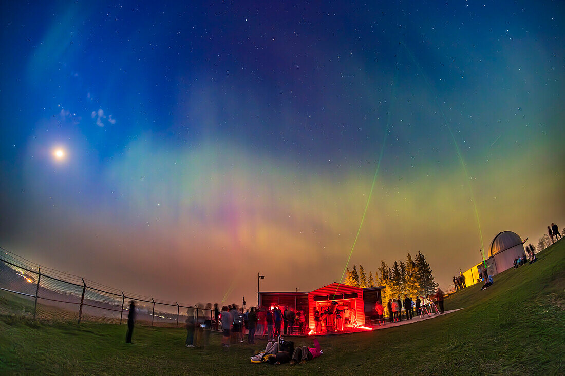 An aurora appears across the northern sky over the University of Calgary's Rothney Astrophysical Observatory on May 11, 2024 during one of the RAO's monthly Space Nights with talks and telescopes for the public. The RAO is near Priddis, southwest of Calgary, Alberta. Telescopes are staffed by members of the Calgary Centre of the Royal Astronomical Society of Canada.