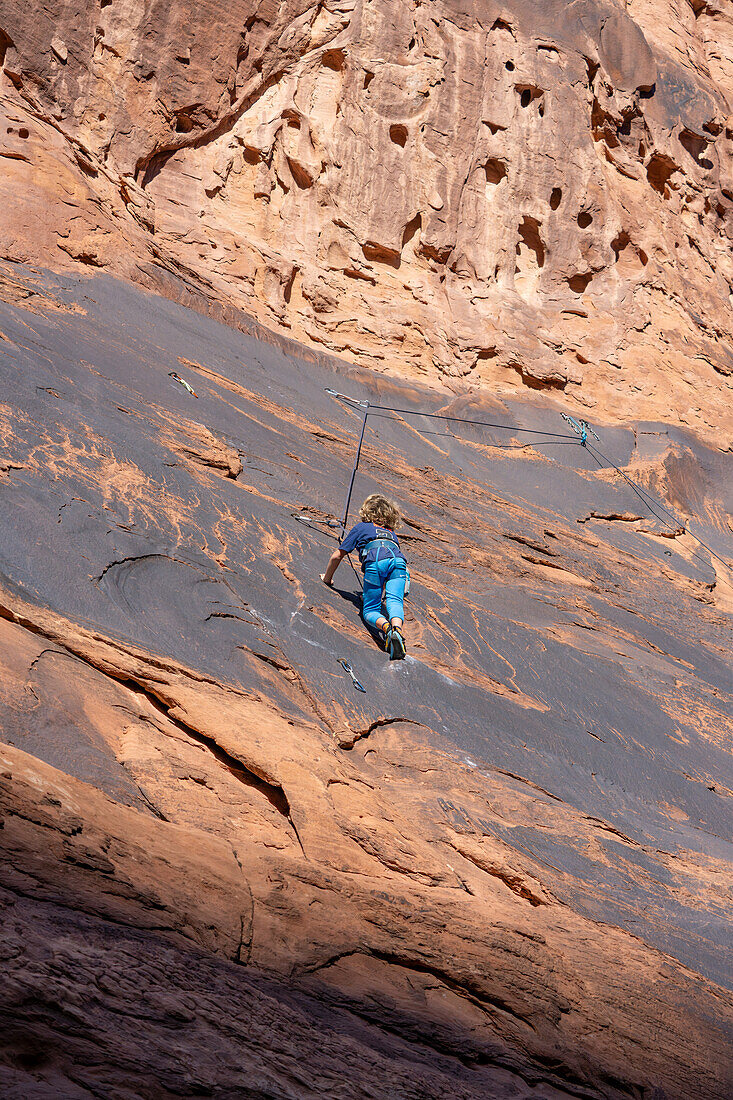 Ein 6-jähriger Junge lernt im Hunter Canyon in der Nähe von Moab, Utah, das Klettern.