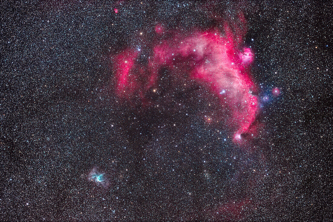 This frames two contrasting nebulas on the border of Canis Major and Monoceros. At top is the large Seagull Nebula or IC 2177, an area of mostly red hydrogen-alpha emission and is a region of star formation, though it contains some blue reflection nebulas.