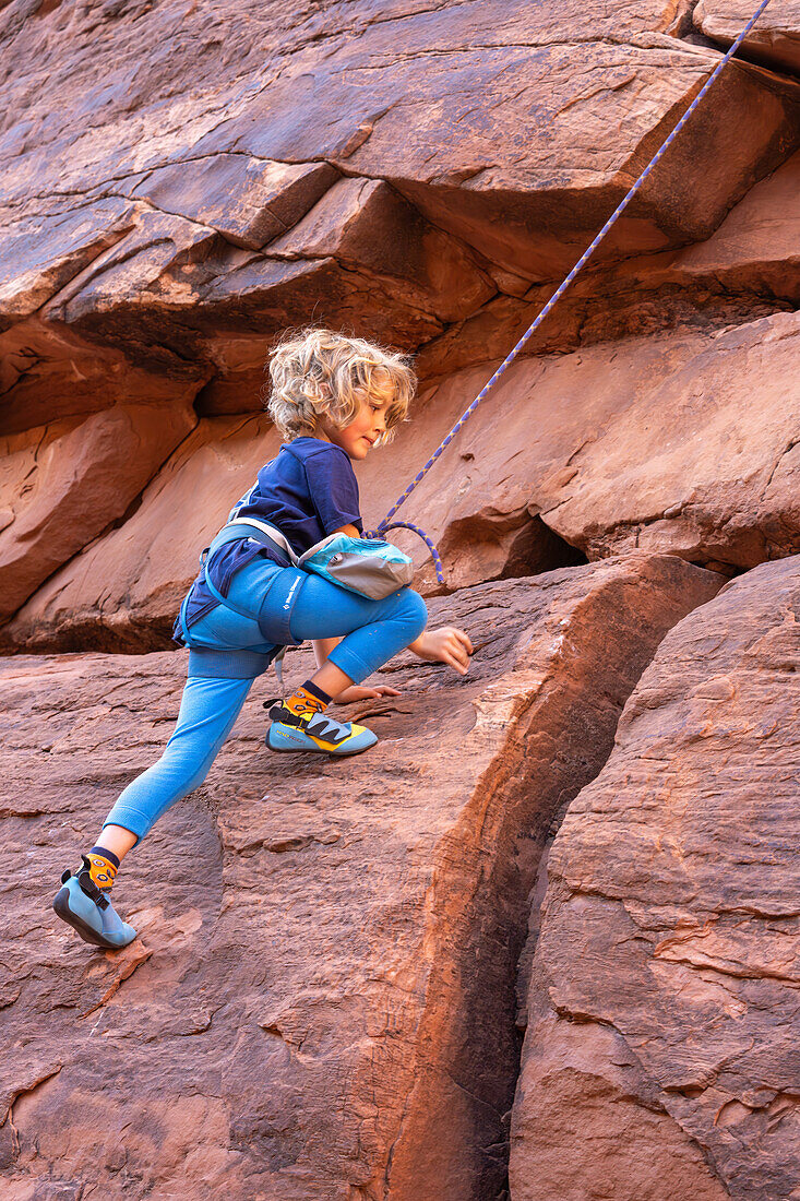 A young boy, age 6, learning to rock climb in Hunter Canyon near Moab, Utah.