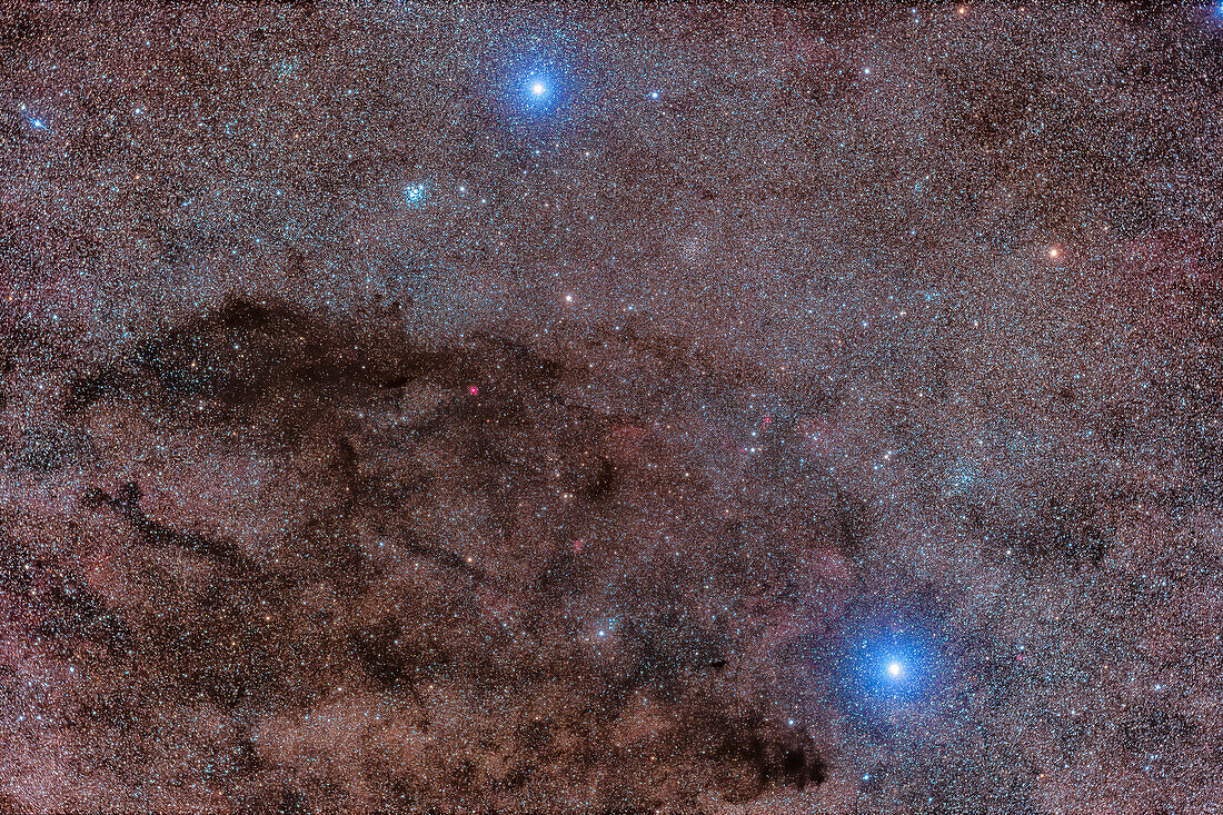 This frames the dark Coal Sack nebula in Crux, the Southern Cross, here recorded as multiple dark lanes, though to the eye the Coal Sack appears as one solid dark region in the Milky Way. The bright star at bottom is Acrux, or Alpha Cruxis, while the star at top is Becrux, or Beta Cruxis. Acrux is a superb double star in a telescope but it is not resolved here at this scale.