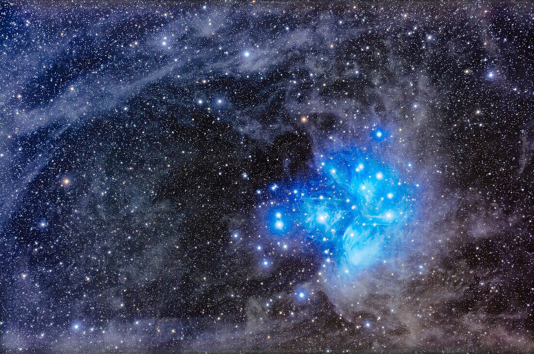 This frames the famous Pleiades or Seven Sisters star cluster (aka Messier or M45) set amid a dusty starfield in Taurus. The blue stars of the Pleiades are surrounded by bright blue reflection nebulosity, most prominent below the lower star Merope, a bit of nebula catalogued separately as NGC 1435. The odd horizontal spike above Merope is real and is catalogued as van den Bergh 20.