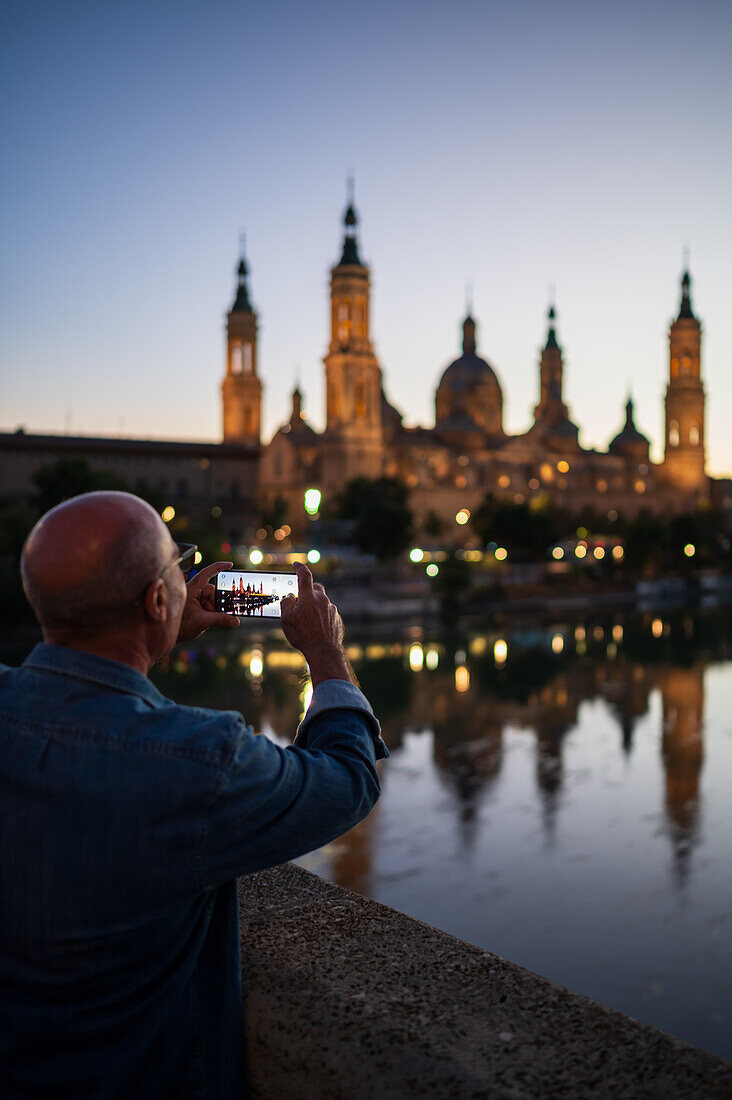 Besucher fotografieren die Kathedrale-Basilika Unserer Lieben Frau von der Säule bei Sonnenuntergang, Zaragoza, Spanien