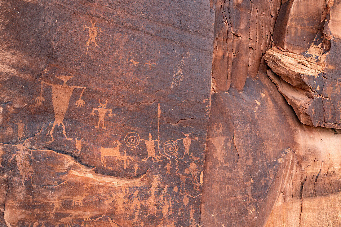 Prähistorische Petroglyphen der Fremont-Kultur, die Krieger, teilweise mit Schilden, auf einer Sandsteinwand in der Nähe von Moab, Utah, darstellen.