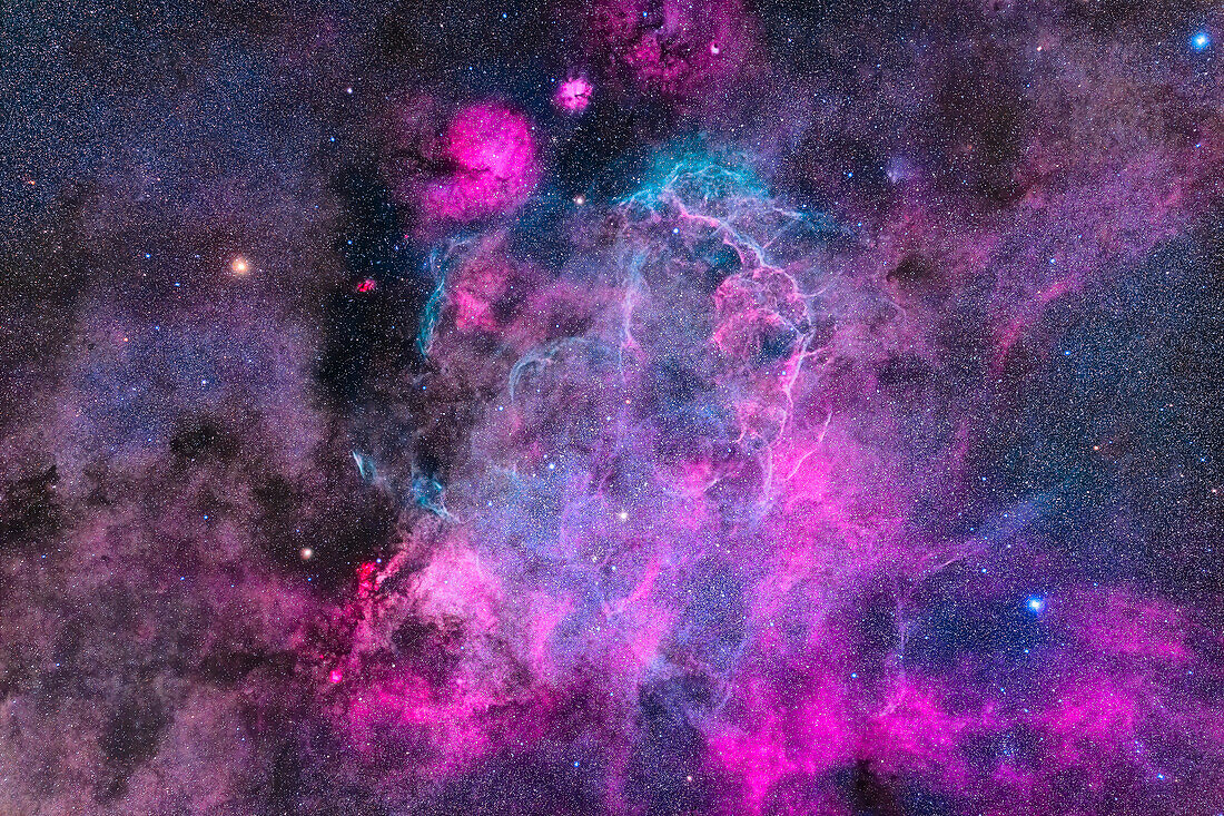 This is the large Vela Supernova Remnant – visible here as the mostly cyan wisps and strands of starstuff from a star that exploded about 11,000 years ago when it was about 900 light years away. It would have been a spectacular sight in our sky at that time.