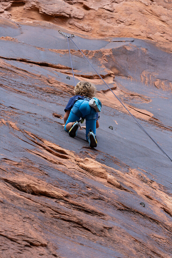 A young boy, age 6, learning to rock climb in Hunter Canyon near Moab, Utah.