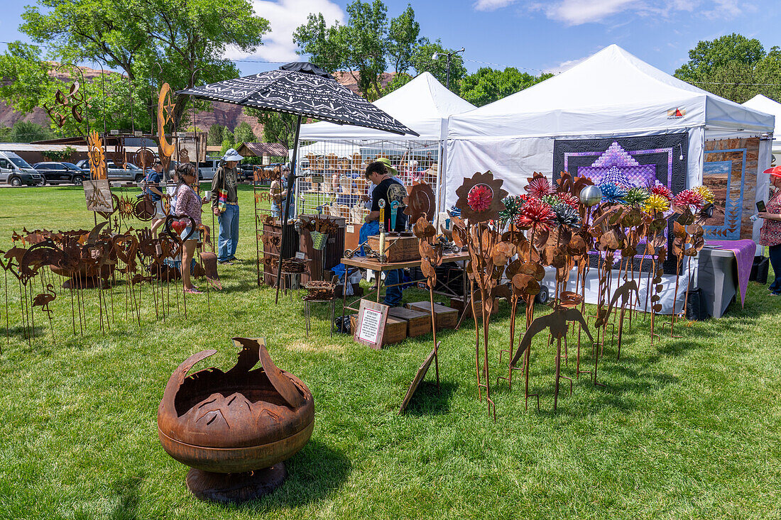 Eine Auslage mit skurriler Kunst aus Metall, die auf dem jährlichen Moab Arts Festival in Moab, Utah, zum Verkauf steht.