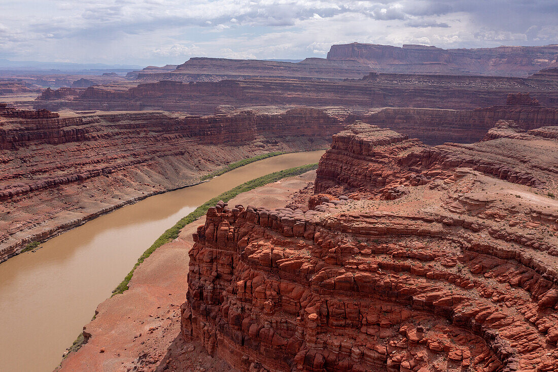 Erodierter Cutler-Sandstein am Fossil Point entlang des Shafer Trail am Colorado River bei Moab, Utah. Das Bears Ears National Monument befindet sich links auf der anderen Seite des Flusses, mit dem Canyonlands National Park im Hintergrund. Hinweis: Die Drohne wurde legal außerhalb der Grenzen der Parks geflogen.