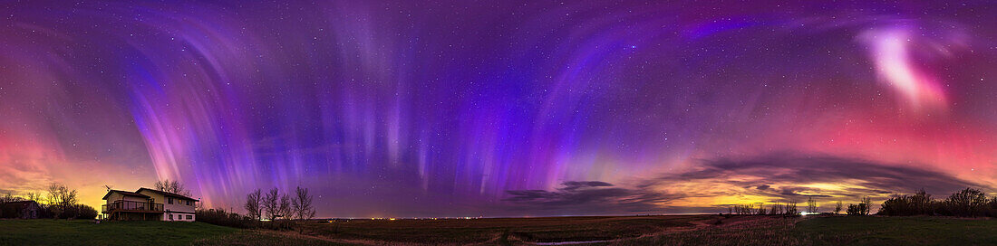 This is a 360° panorama of the May 10/11, 2024 great aurora display, when the Kp Index reached 8 this night bringing aurora to as far south as the southern U.S. Here, from my home in southern Alberta, Canada (latitude 51° N) it is exhibiting very odd vertical blue and magenta rays across the western (left), and northern and eastern sky (centre), and an odder bright patch to the south at far right. This was toward the end of the main activity of the show for me this night, at about 2:30 am. These distinctive blue rays appeared like this only at this time after the main show died down. The colou