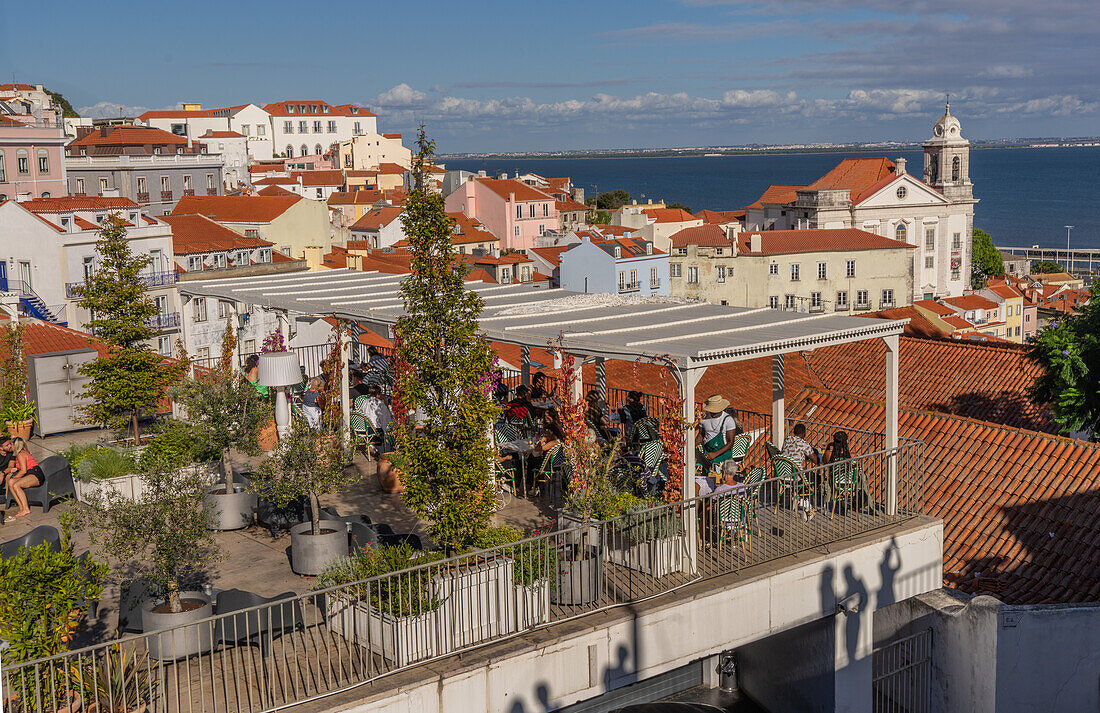 Touristen und Besucher genießen die Aussicht von Bars und Restaurants auf die Stadt bei Sonnenuntergang in Lissabon, Portugal, Europa