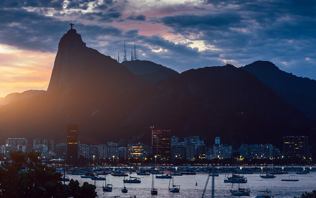 Blick auf die Bucht von Botafogo bei Sonnenuntergang mit der Christus-Erlöser-Statue im Hintergrund, UNESCO-Weltkulturerbe, zwischen Berg und Meer, 2012 in die Liste des Weltkulturerbes aufgenommen, Rio de Janeiro, Brasilien, Südamerika