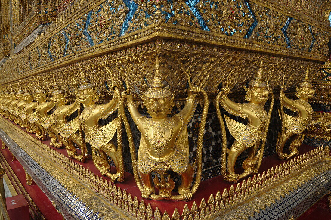 Small Garudas at the base of the Emerald Buddha temple holding a naga (mythical snake creature), Bangkok, Thailand, Southeast Asia, Asia